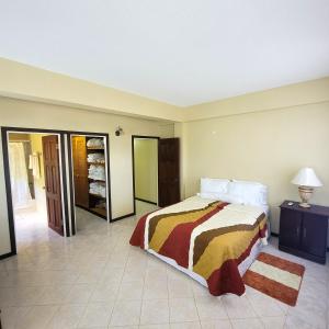 una camera con un letto e una stanza con una porta di Venance Grand Yer apt 2 Enjoys Sea Views in Rodney Heights a Gros Islet