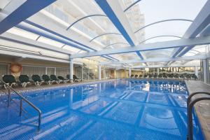 a large swimming pool with chairs in a building at Hotel Rosamar Garden Resort 4* in Lloret de Mar