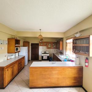 una cucina con armadi in legno e frigorifero bianco di Venance Grand Yer apt 2 Enjoys Sea Views in Rodney Heights a Gros Islet