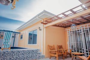 um pátio com uma pérgola, uma mesa e cadeiras em Heavenly ApHEARTment with backyard swimming pool em Dodoma