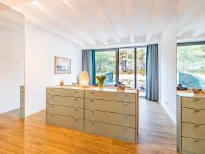 een witte kamer met een dressoir en een raam bij FeWo Prora - Sunny in Binz