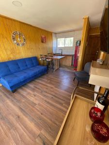 sala de estar con sofá azul y mesa en Cabañas Borde Lindo, en San José de la Mariquina