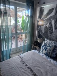 - une chambre avec un lit et une vue sur une terrasse dans l'établissement LE BALI, à La Grande Motte