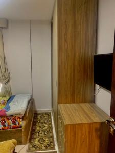 een kleine kamer met een bed en een dressoir bij Portosaid بورتو سعيد (غرفه وصاله ) in `Ezbet Shalabi el-Rûdi