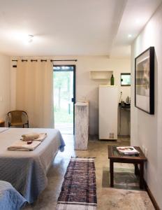 Cette chambre comprend deux lits, une table et un réfrigérateur. dans l'établissement AKASHA Atelier Santa Helena, Sana, à Sana