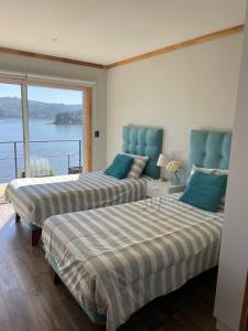 2 camas en una habitación con vistas al agua en Lago Vichuquen, en Vichuquén
