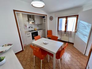 a kitchen and dining room with a white table and chairs at Appartamenti Via Roma 41 in Campo nell'Elba