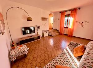 a living room with a couch and a television at Appartamenti Via Roma 41 in Campo nell'Elba