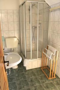 y baño con ducha, aseo y lavamanos. en Pension Kronenburghof, en Erfurt