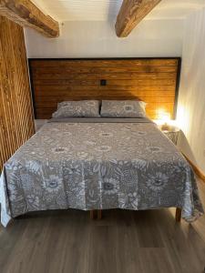 a bedroom with a large bed with a wooden headboard at Ta Serafina studio apartment with loft in Għajnsielem