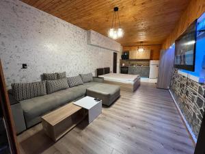 uma sala de estar com um sofá e uma mesa em Апартаменти Dream em Sarnitsa