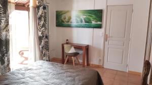 Schlafzimmer mit einem Bett, einem Schreibtisch und einem Fenster in der Unterkunft Le cottage du Littoral de Petit Havre in Le Gosier