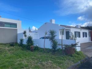 een wit huis met planten ervoor bij Estrela do Atlântico in Ponta Delgada