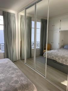 a bedroom with a mirror in front of a bed at Appartement 2 pièces élégant proche Porte de Versailles in Paris