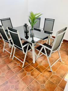 a dining room table with four chairs and a potted plant at Villa Rangel in Olivenza