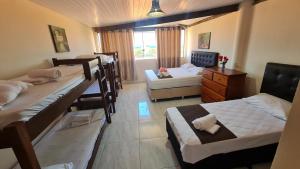 a room with four bunk beds and a window at EcoCasa Rio Sauípe 200 m da Praia in Porto de Sauipe