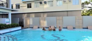 un grupo de personas sentadas en una piscina en New, Modern 2 Bedroom Condo, Free Hi-Speed Wifi, en Iloilo City