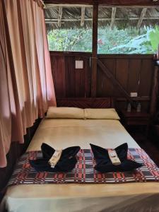 Bett in einem Zimmer mit zwei Kissen darauf in der Unterkunft Isla Ecologica Mariana Miller in Puerto Misahuallí