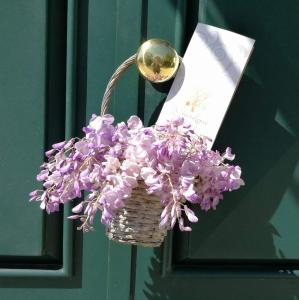un cesto pieno di fiori viola accanto a una porta di Il Giardino del Tè a Barletta
