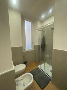 een badkamer met een glazen douche en een toilet bij Monolocale open space in Legnano