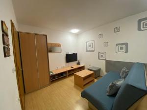 a living room with a blue couch and a television at APARTMA BRDO BC in Bovec