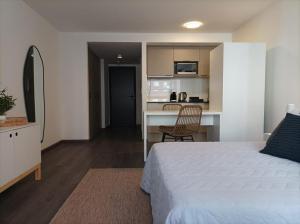 1 dormitorio con 1 cama blanca y cocina en Apartamento a estrenar en Punta Carretas en Montevideo