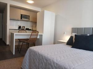 1 dormitorio con cama, mesa y cocina en Apartamento a estrenar en Punta Carretas, en Montevideo