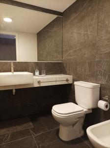 y baño con aseo blanco y lavamanos. en Apartamento a estrenar en Punta Carretas, en Montevideo