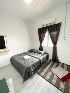 um quarto com uma cama e uma janela em Eager Homestay em Kuala Lipis