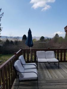 two chairs and an umbrella on a wooden deck at Great Escapes,Rhinog mountain View in Trawsfynydd
