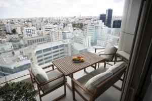 a table and chairs on a balcony with a view of a city at 360 Nicosia - 2 bedrooms Luxury Residence in Nicosia