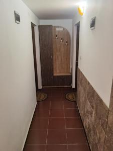 korytarz z drzwiami i podłogą wyłożoną kafelkami w obiekcie House for Guests and Friends w mieście Swisztow