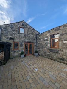 a brick house with a patio in front of it at Charming 1-Bed Cottage on the outskirts of Haworth in Keighley