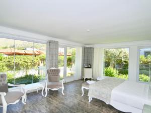 a bedroom with a large bed and windows at Göcek Naz Hotel in Göcek