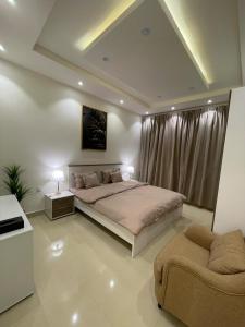 a large bedroom with a large bed and a couch at شقق ارفلون دخـول ذاتي in Riyadh