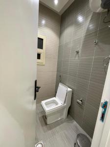 a bathroom with a white toilet in a stall at شقق ارفلون دخـول ذاتي in Riyadh
