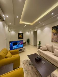 a living room with a couch and a tv at شقق ارفلون دخـول ذاتي in Riyadh