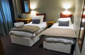 a hotel room with two beds and a table at The Penny Farthing Hotel in Berkhamsted