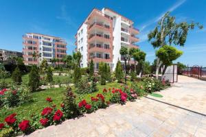 a garden with flowers in front of a building at Ривиера форт бийч (Riviera Fort Beach) - Равда in Ravda