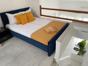 a bedroom with a blue bed with yellow pillows at Sea View Loft in Nea Roda