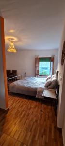a bedroom with a large bed with a window at Cuevas Los Coloraos - La Residencia in Villanueva de las Torres
