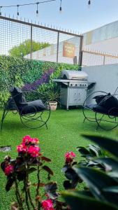 a backyard with a grill and chairs and flowers at Cocoloft de Diseño in Buenos Aires