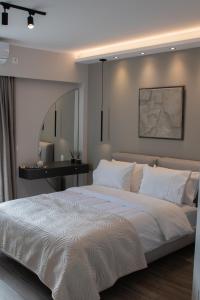 sypialnia z dużym białym łóżkiem i biurkiem w obiekcie Langi Apartments w mieście Missolungi