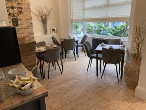 a dining room with tables and chairs and a window at Summer Breeze in Newquay