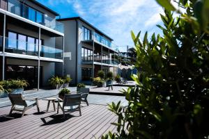un patio de un edificio con sillas y mesa en 4 Woolacombe West - Luxury Apartment at Byron Woolacombe, only 4 minute walk to Woolacombe Beach!, en Woolacombe