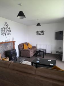 a living room with a couch and a fireplace at Fonn Na Mara in Campbeltown