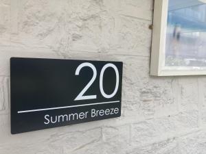 un cartello su un edificio che legge la brezza estiva di Summer Breeze a Newquay