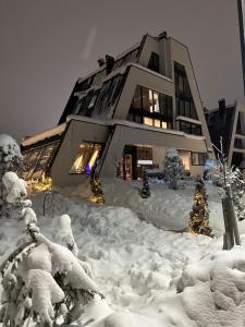 a building covered in snow with christmas trees at Ski & Relax Apartment Bjelašnica in Bjelašnica