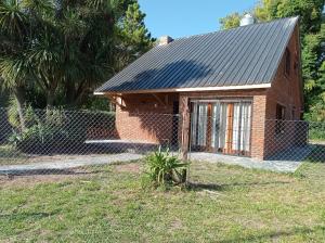 una pequeña casa de ladrillo con techo de metal en Casa en Mar del Plata, Alfar en Mar del Plata
