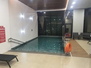 een zwembad in een gebouw met een zwembad bij Estúdio Completo com Linda Vista no Ed. Vertigo in Campo Grande